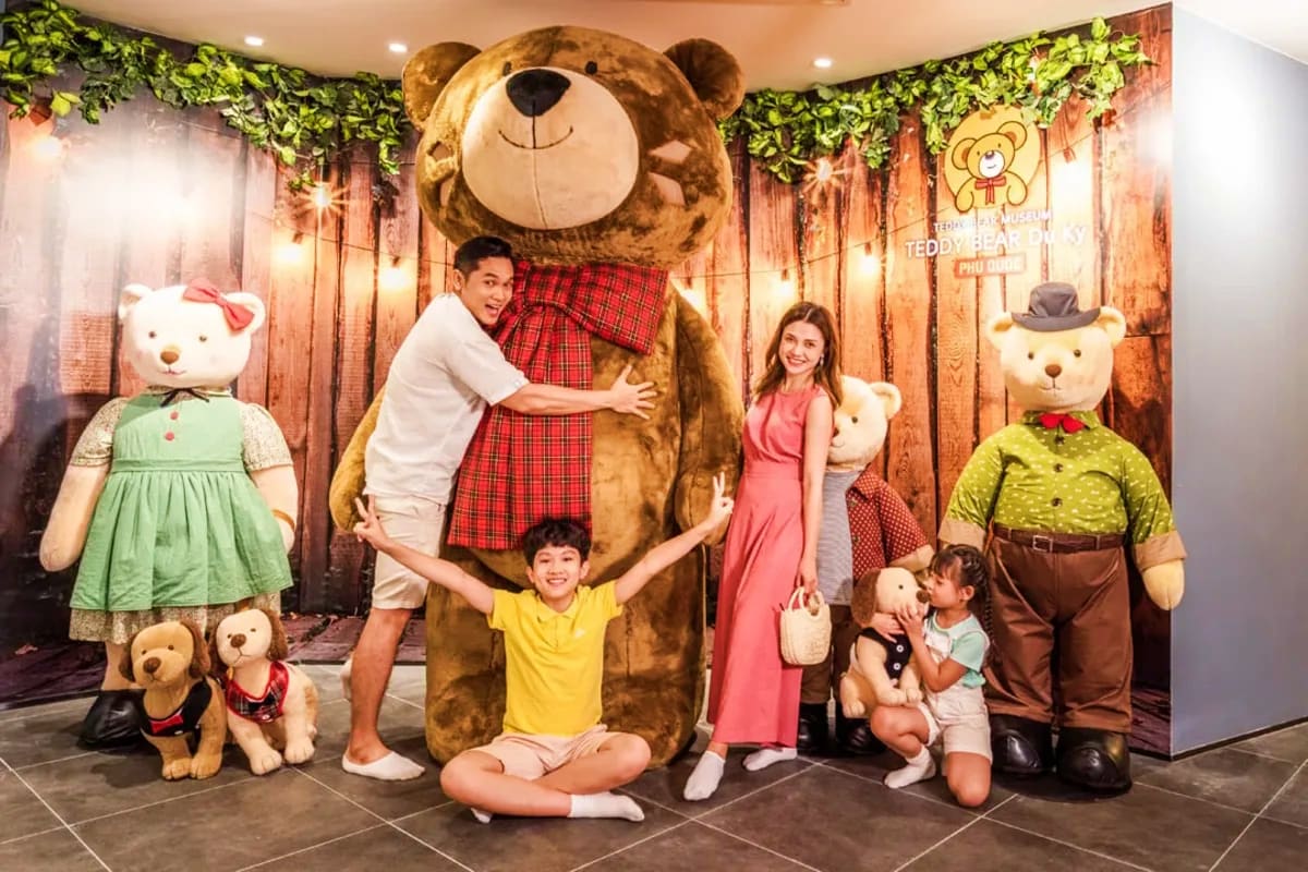 Grand World with Gondola Ride Family posing with giant teddy bear and costumed characters at teddy bear themed attraction display