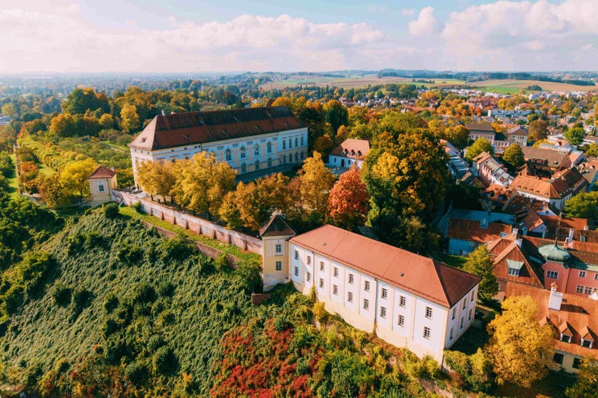 Aerial view of Dachau Castle with autumn foliage, surrounding town, and countryside landscape in Bavaria, Germany