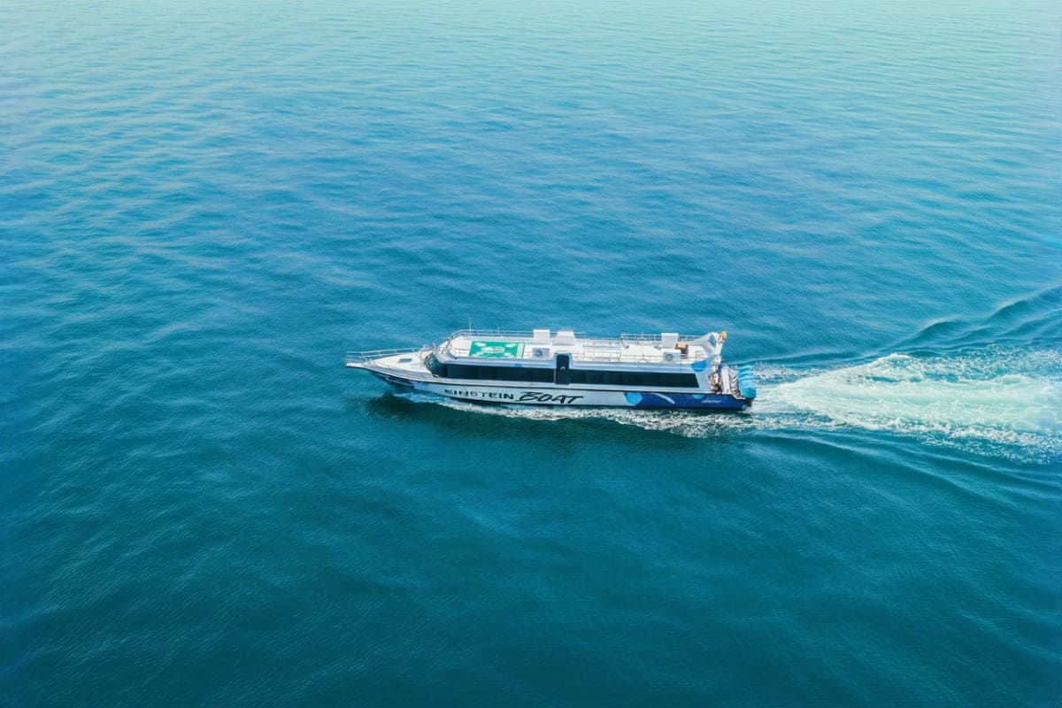 Fast Boat Ticket between Bali Lombok and Nusa with Gili Islands White and blue fast boat with "Gili Boat" branding traveling through turquoise ocean waters between Indonesian islands