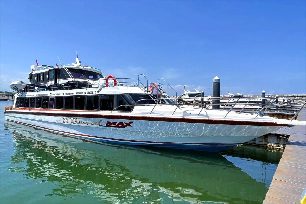 D'Ozvel MAX fast boat docked at marina with clear blue water and sky, passenger ferry for Bali Lombok Gili Islands transport