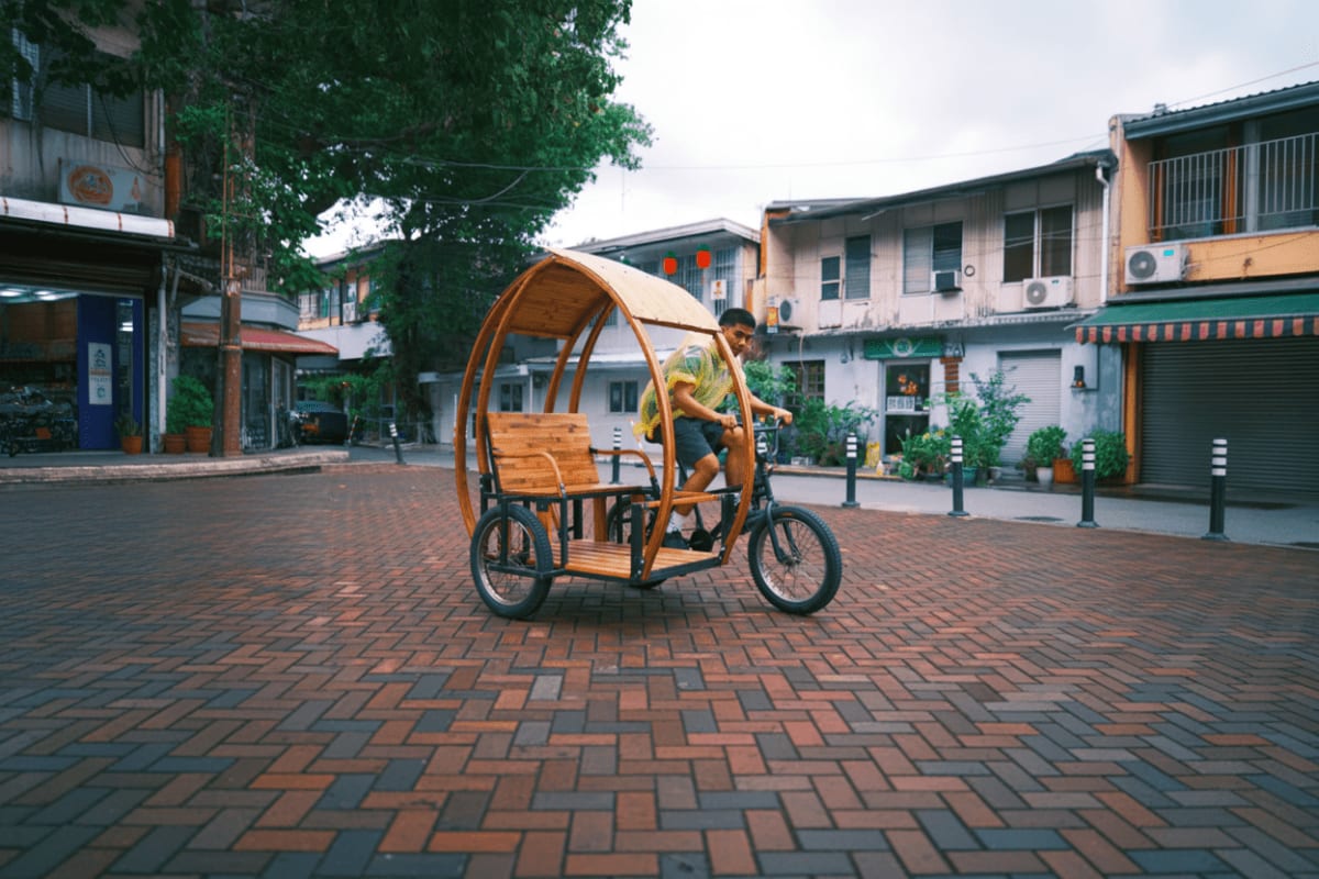 Intramuros Bambike Tour Man riding a wooden Bambike pedicab on a brick-paved street in historic Intramuros district with colonial buildings in backgr