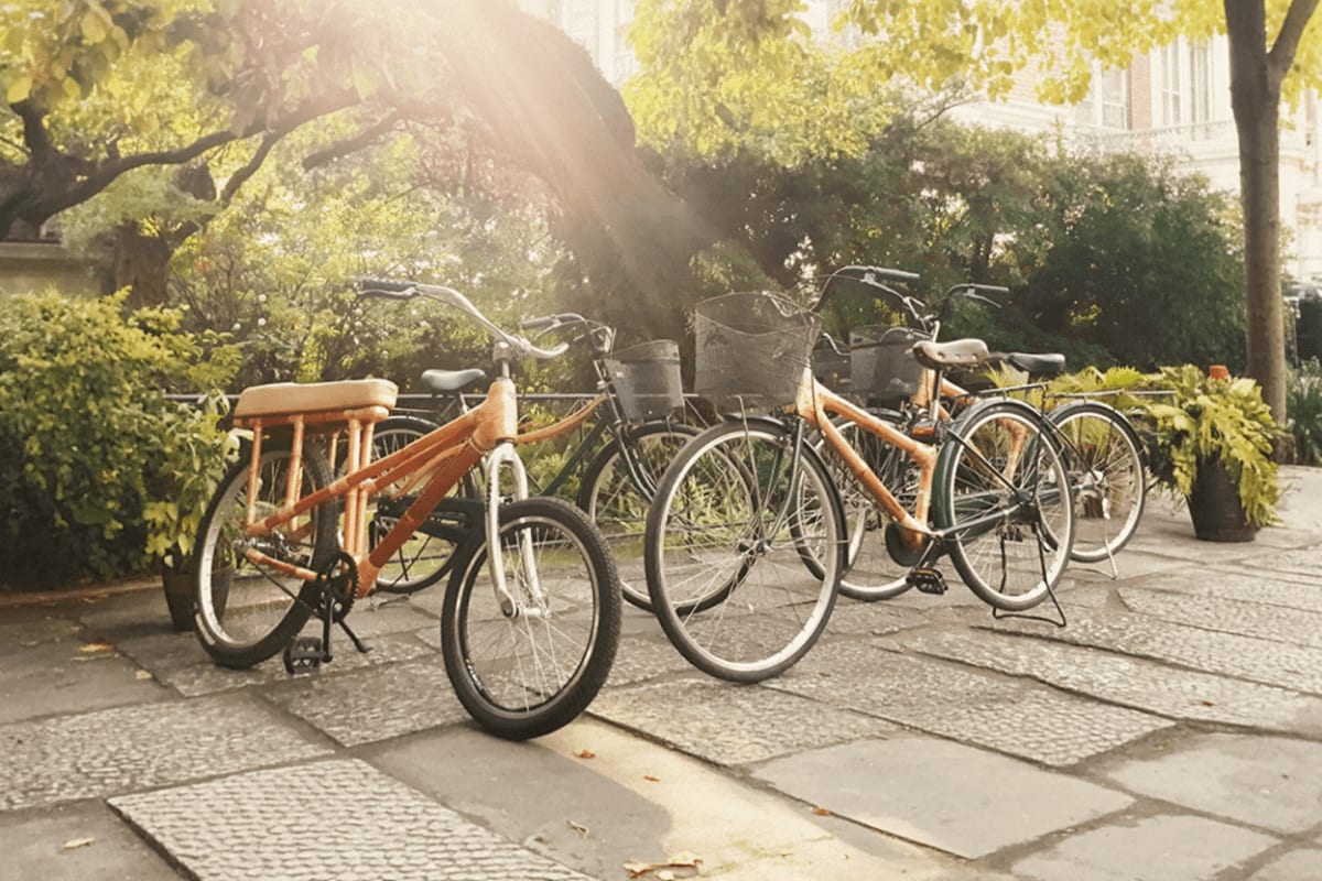 Intramuros Bambike Tour Row of bamboo and wooden bicycles parked on a cobblestone street with trees and historic buildings in background