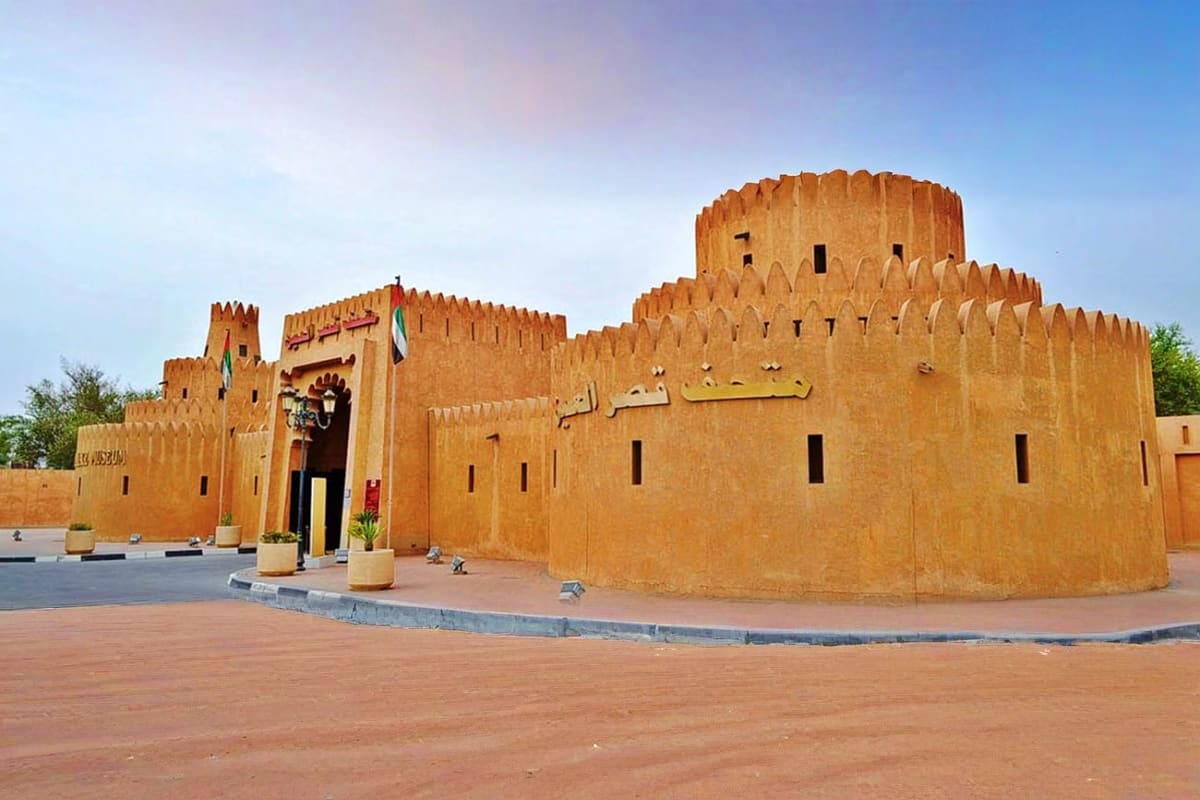 Historic clay fortress with crenellated walls and Arabic calligraphy in Al Ain, UAE
