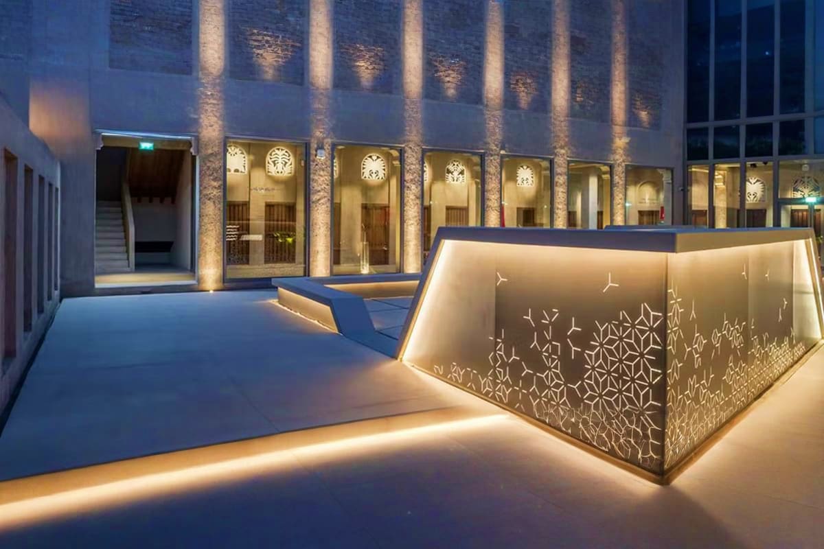 Al Shindagha Museum Modern courtyard of Al Shindagha Museum at dusk with illuminated architectural features, clock displays, and geometric patter