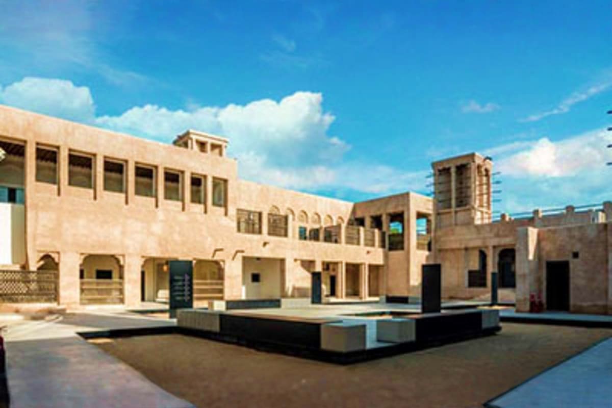 Al Shindagha Museum Modern sandstone building with traditional Islamic architecture featuring courtyards and wind towers under blue sky at Al Shi