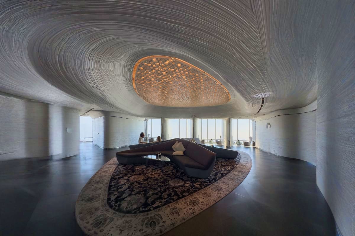 Modern lounge area inside Burj Khalifa with curved ceiling, sculptural black seating, panoramic windows overlooking Dubai sky