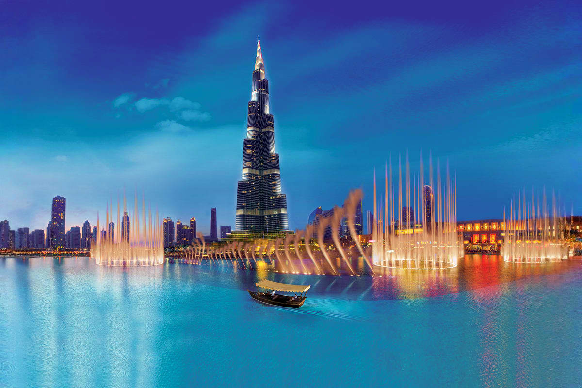 Dubai Fountain Show and Lake Ride Burj Khalifa tower with illuminated fountain show on Dubai Lake at dusk, traditional abra boat in foreground
