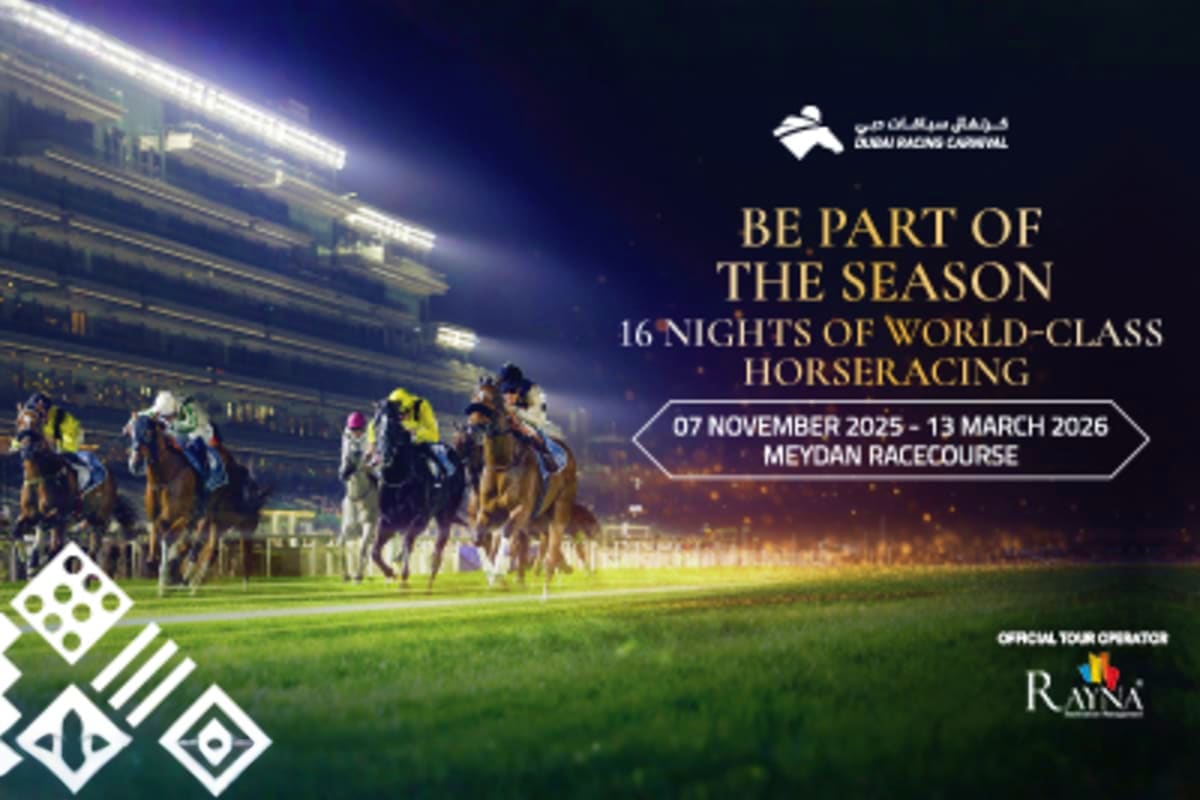 Horses and jockeys racing at night on illuminated Meydan Racecourse in Dubai during horse racing event