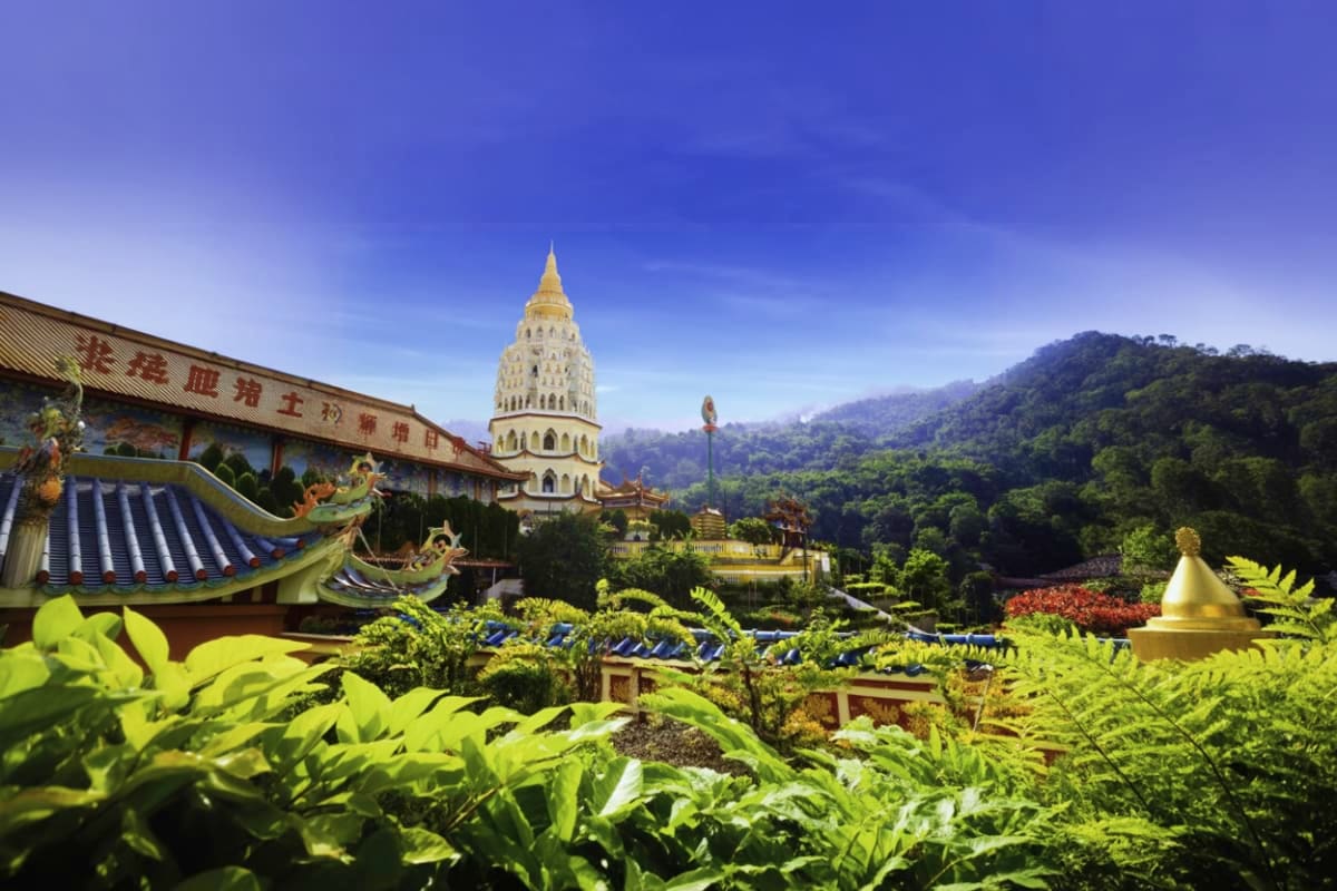 Half Day Penang City Tour Kek Lok Si Temple with golden pagoda and traditional Chinese architecture surrounded by lush green gardens and forested hills