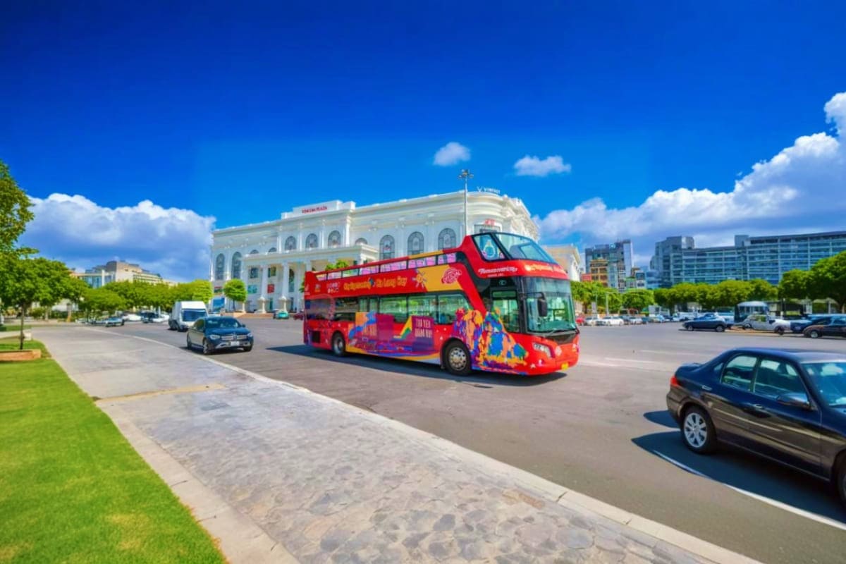 Hop on Hop off Bus Red double-decker hop-on hop-off tour bus in city square with historic white building and blue sky