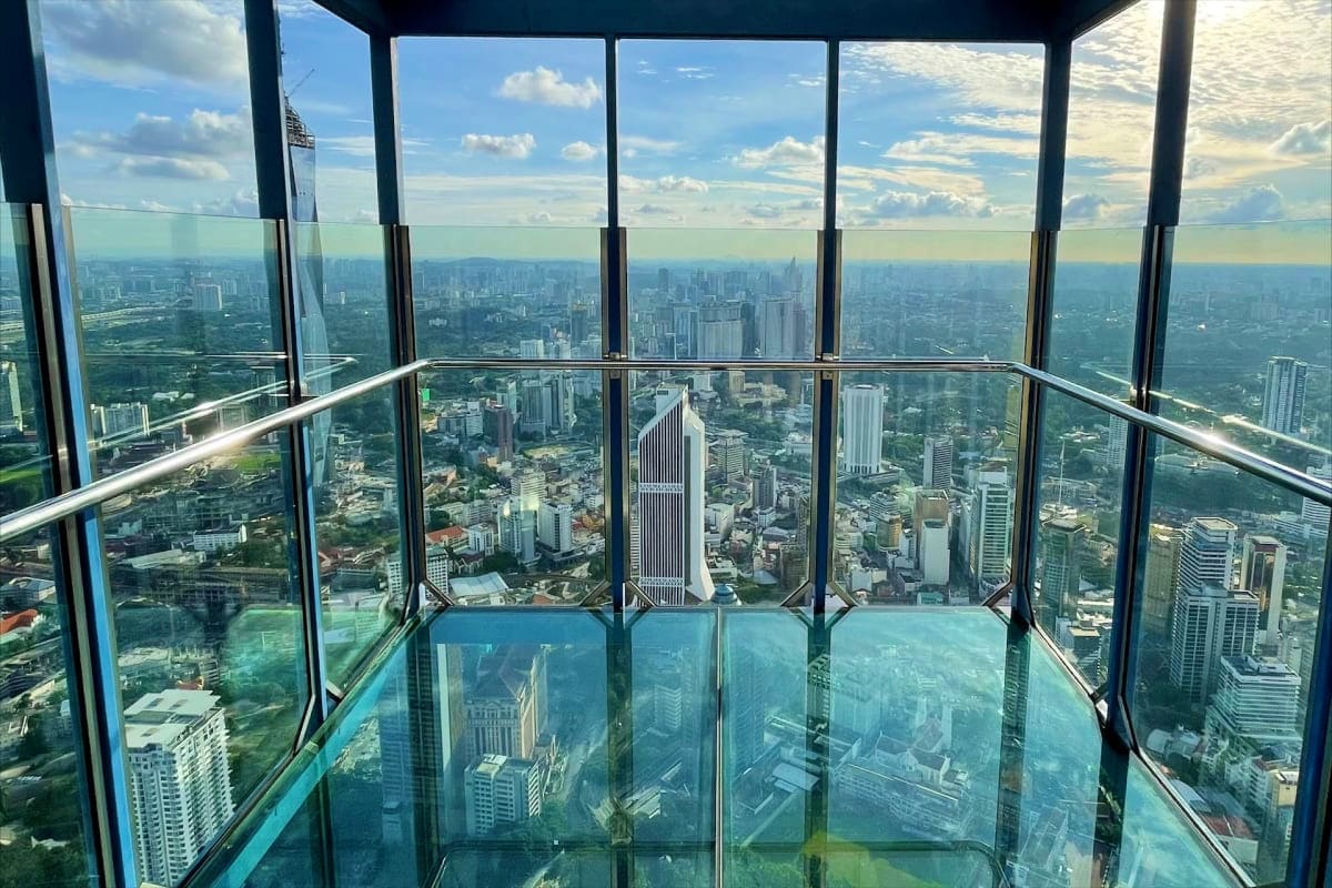 View from KL Tower observation deck overlooking Kuala Lumpur skyline with modern skyscrapers and green spaces below