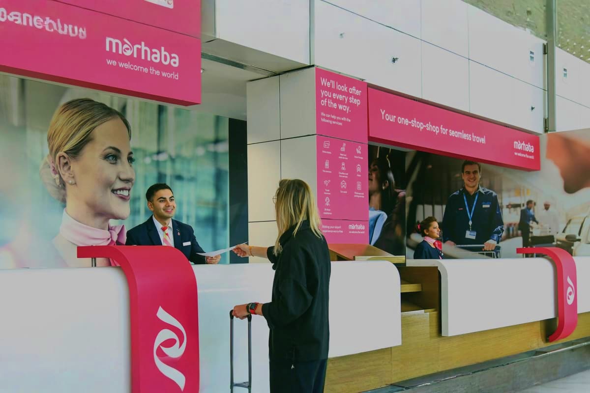 Marhaba Services Dubai Marhaba Services airport counter with staff assisting travelers, showing pink and white branded desk and signage for seamless
