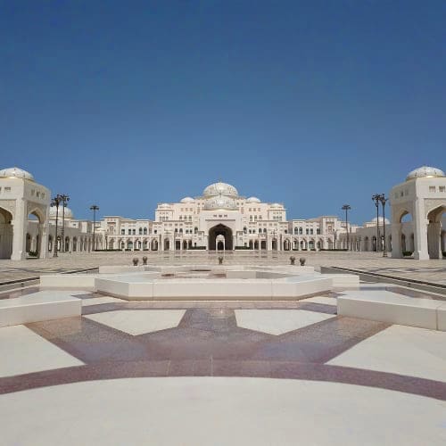 Symmetrical view of Qasr Al Watan palace courtyard with white marble architecture, central dome, and clear blue sky in Abu Dh