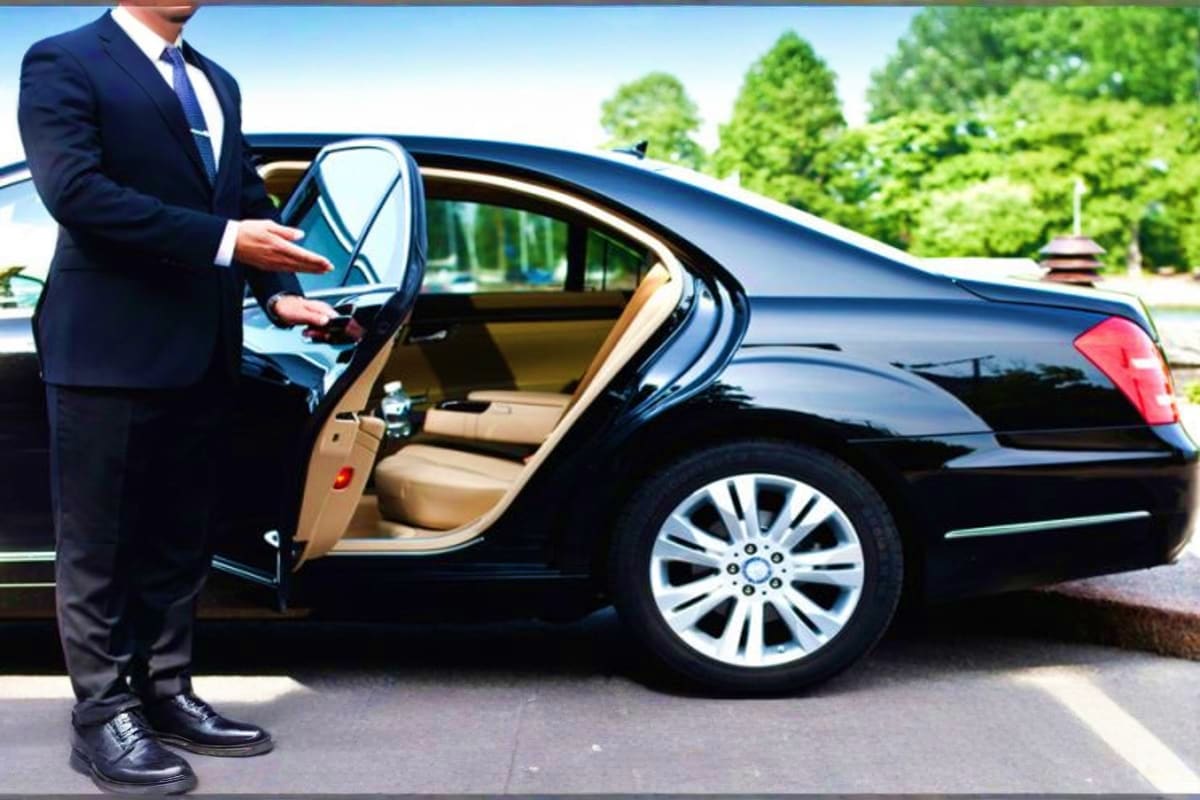 Singapore Cruise Pick up Businessman in dark suit standing beside black luxury sedan with open door and beige interior, showing professional car servi