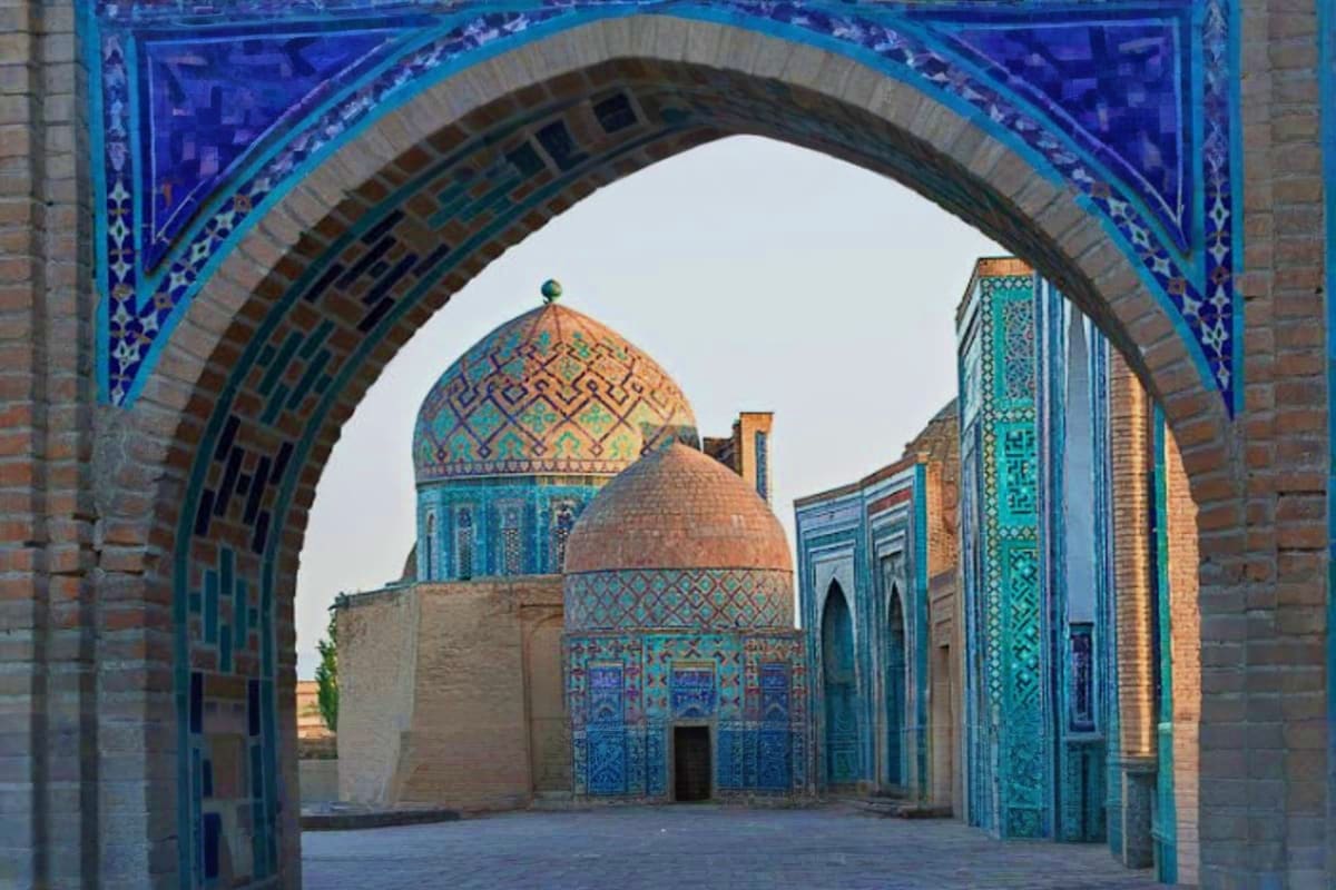 Ornate blue-tiled Islamic archway framing domed mosque with turquoise tilework and geometric patterns in historic Tashkent co