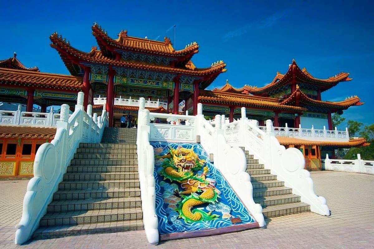 The Great Kuala Lumpur Iconic Attractions Tour Chinese Buddhist temple with ornate golden roof and red pillars, white marble balustrade with blue dragon mosaic detail on ce