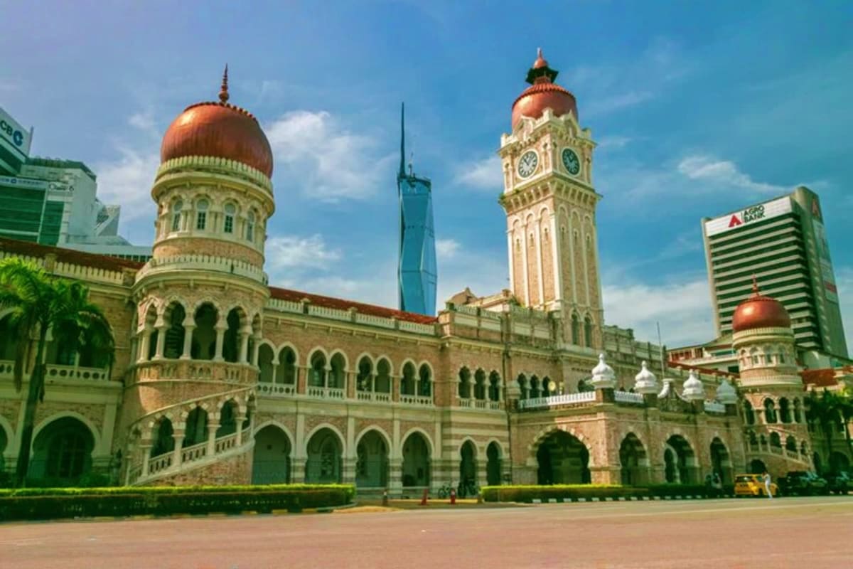 The Great Kuala Lumpur Iconic Attractions Tour Sultan Abdul Samad Building in Kuala Lumpur with distinctive copper domes, clock tower, and colonial architecture against blu