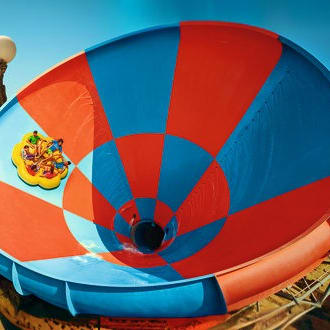Hot air balloon with blue and red panels inflating against clear sky at Yas Water World Abu Dhabi