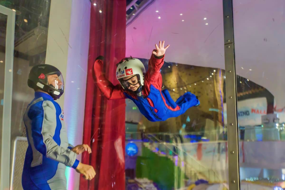 iFly Dubai Indoor skydiving simulator display with mannequin in blue and red suit with helmet, arms raised in flying position at iFly Du