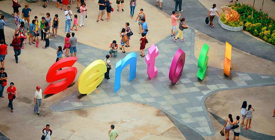 Full Day Sentosa Island Tour Aerial view of colorful Sentosa Island sign with tourists walking around public plaza area