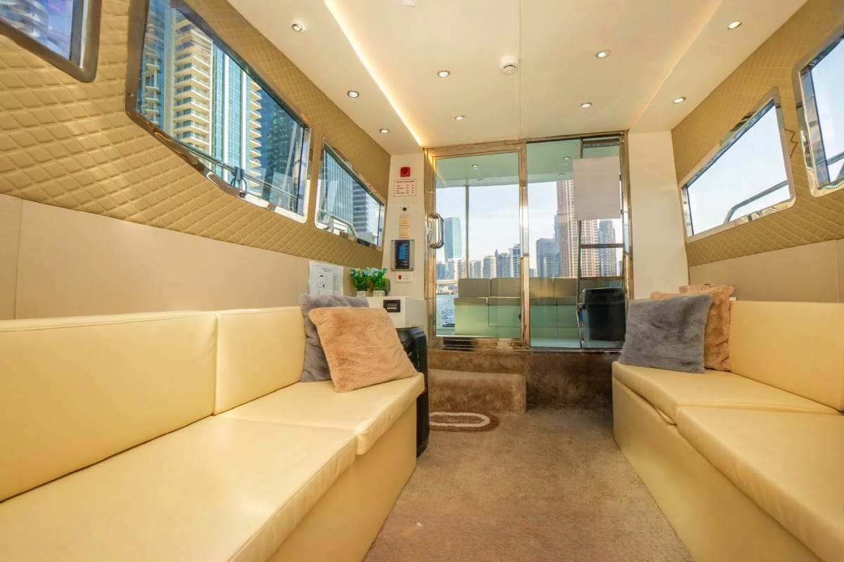 Interior of 40 Ft Riverside Yacht with cream-colored seating, skyline views through windows, and modern cabin design