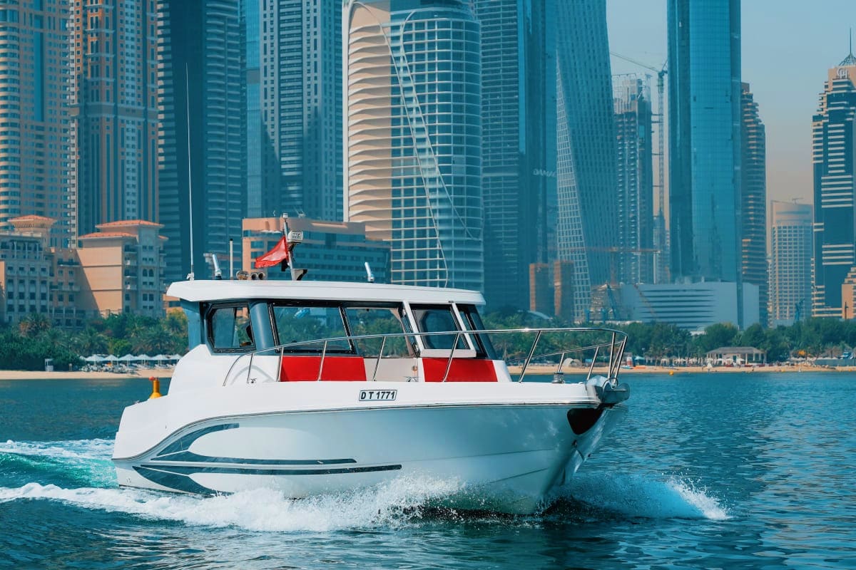Silver Craft X13 White and red Silver Craft X13 yacht moving through water with Dubai Marina skyscrapers in background