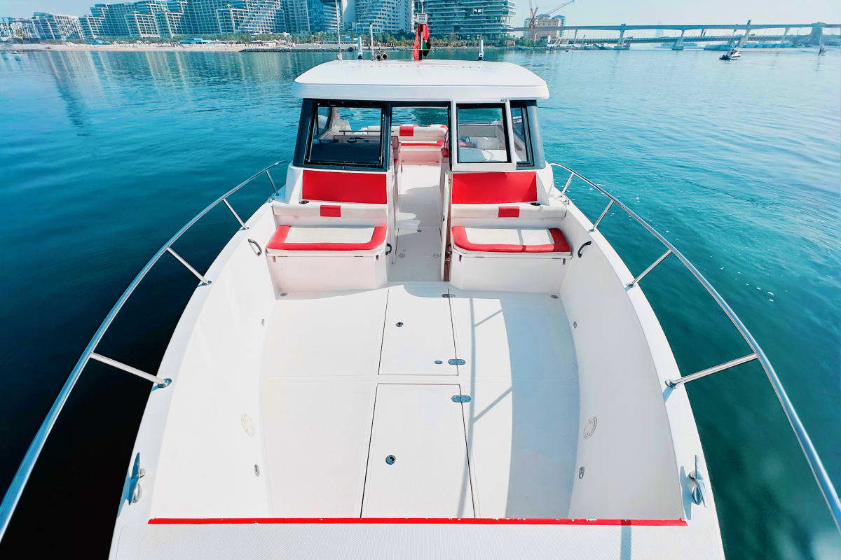 Silver Craft X13 Silver Craft X13 boat moored in blue harbor water with city skyline and bridges in background, front view showing white deck