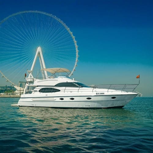 White luxury yacht anchored in turquoise waters with the London Eye ferris wheel in the background under clear blue sky