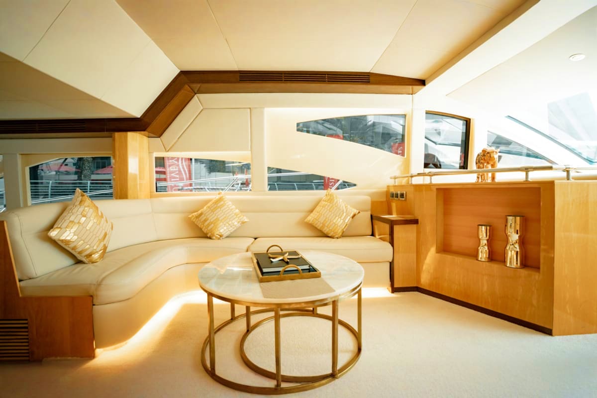 Majesty X3 Luxury yacht interior lounge with cream seating, wooden furnishings, and panoramic windows overlooking water