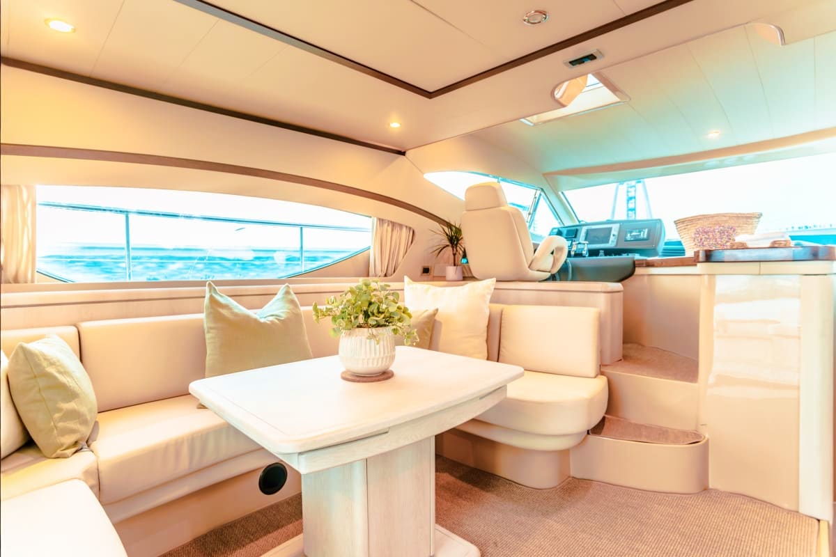 50 Ft Aliona yacht cabin interior with cream seating, white table, ocean view windows, and natural lighting