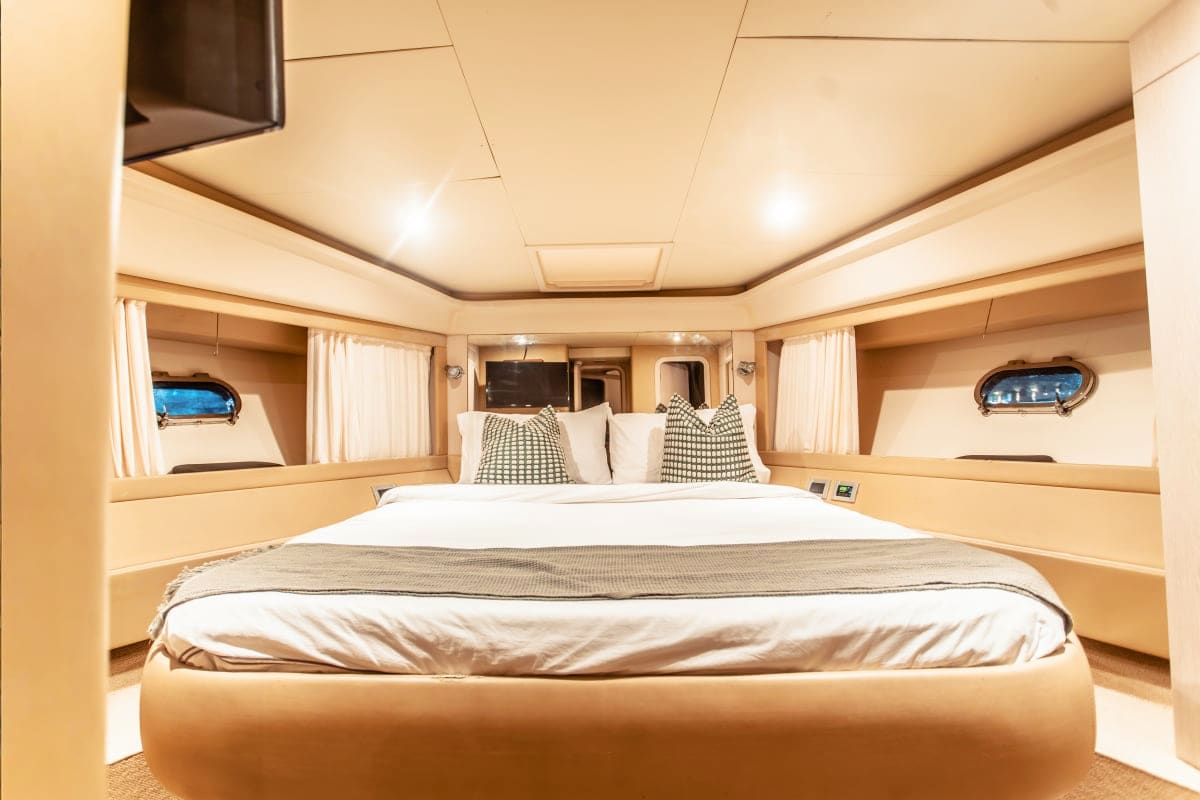Luxurious master bedroom in 50 Ft Aliona yacht with king bed, patterned pillows, cream walls, and ambient ceiling lighting