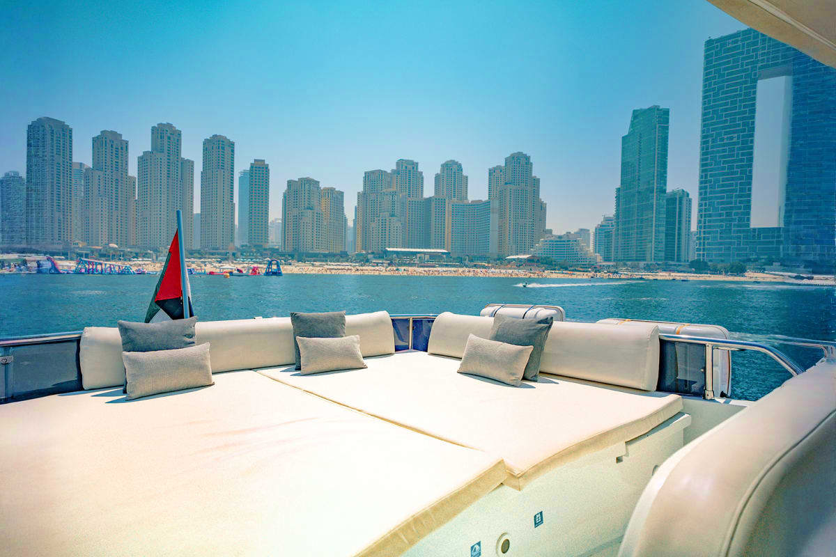 Maiora X12 yacht deck with lounge seating overlooking Dubai Marina skyline and beach