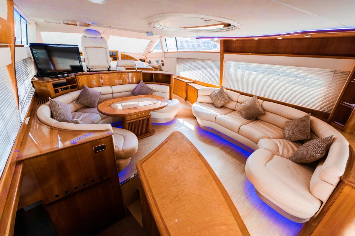58 Ft Etosha Yacht Luxury yacht interior with cream leather seating, wooden cabinetry, flat-screen TV, and blue ambient lighting throughout the