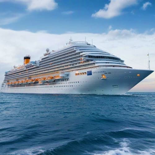 Large modern cruise ship Costa Diadema sailing on calm blue ocean waters under clear sky with white clouds
