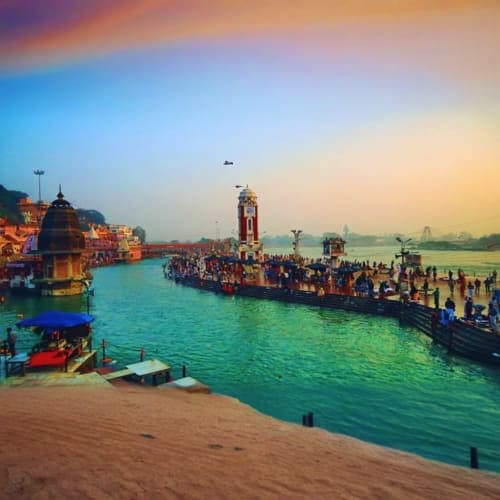 Haridwar ghats at sunset with turquoise Ganges River, pilgrims, temples, and golden hour sky reflecting spiritual atmosphere