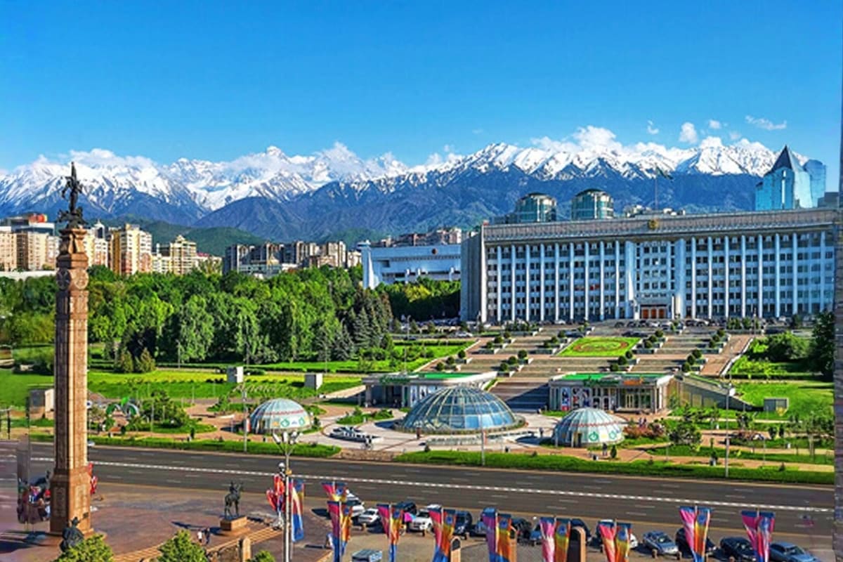 Almaty Highlights Ala-Too Square in Almaty with snow-capped mountains, government buildings, and flags in the background