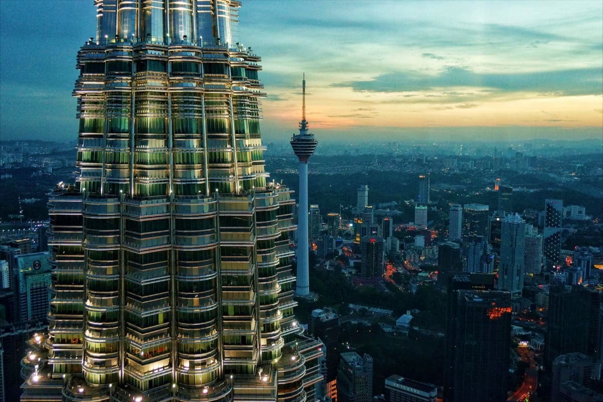 Best of Kuala lumpur and Langkawi Petronas Twin Towers illuminated at dusk with Kuala Lumpur city skyline and communications tower in background at sunset