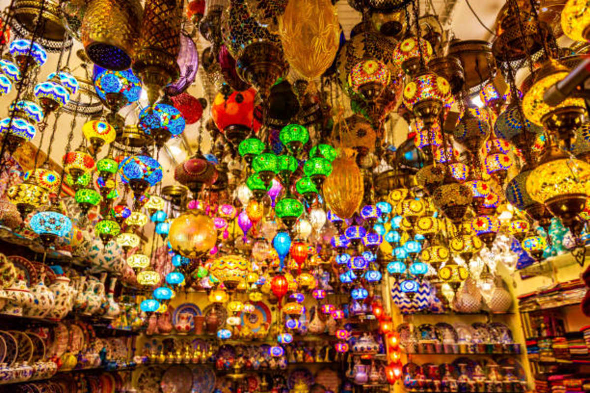 Colorful illuminated Turkish lanterns and decorative glassware hanging from ceiling in traditional marketplace shop display