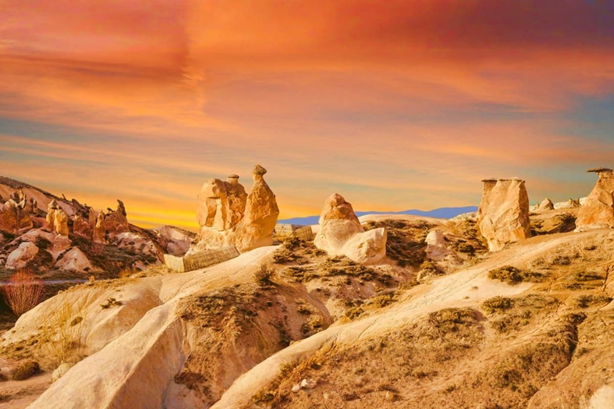 Fairy chimney rock formations in Cappadocia, Turkey at sunset with golden sky and volcanic landscape
