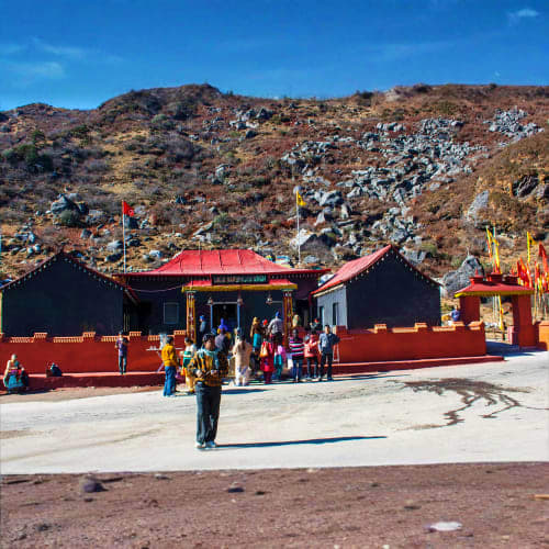 Buddhist monastery with red and black architecture nestled in rocky Himalayan foothills, Sikkim