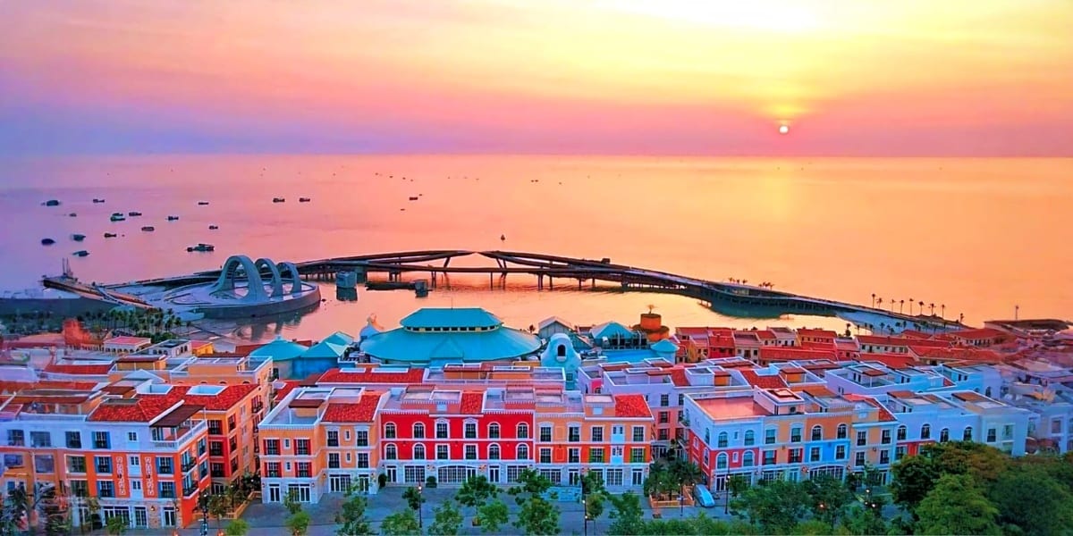 Aerial sunset view of colorful waterfront buildings and futuristic architecture with boats in Phu Quoc harbor at dusk