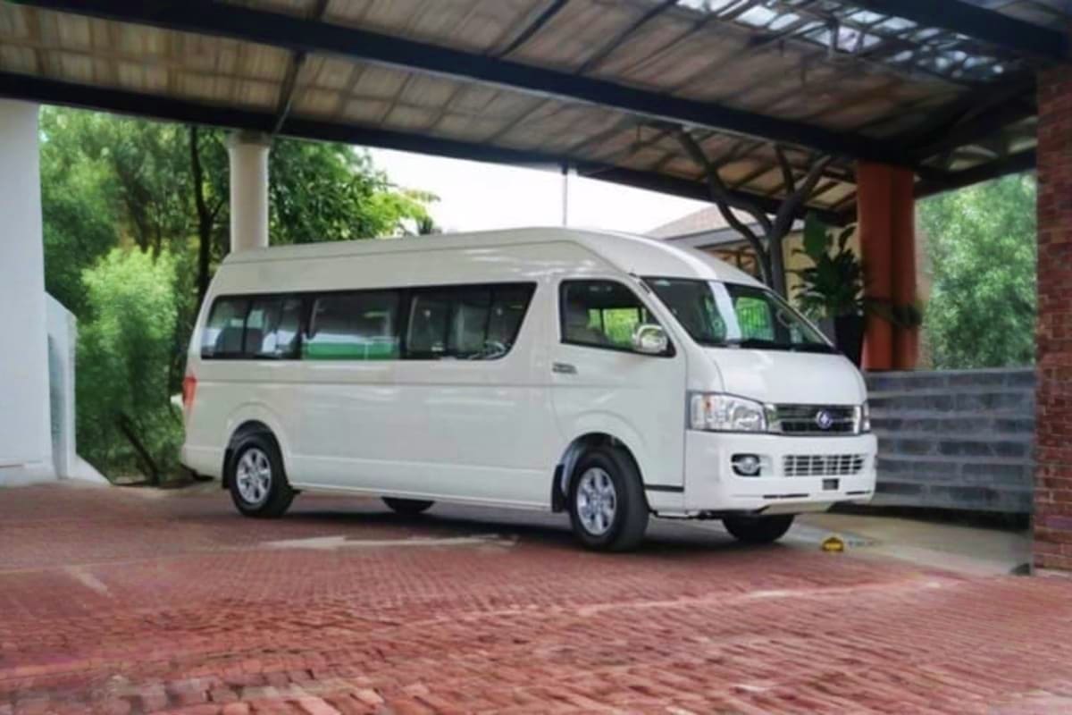 Langkawi Midnight Airport Drop Off White passenger van parked under covered carport at residential driveway for airport transfer service
