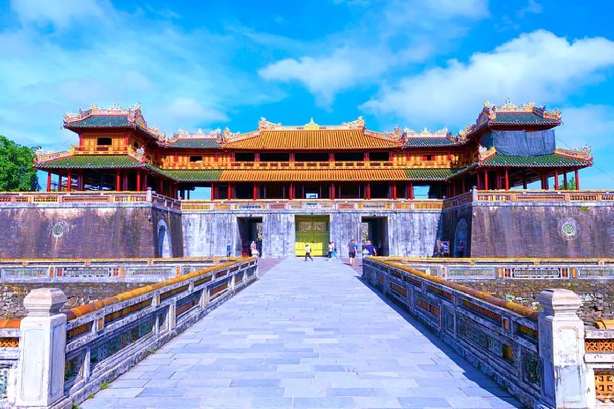 Hue City tour Citadel of Hue with traditional Vietnamese architecture, golden-tiled roofs, and stone courtyard under blue sky