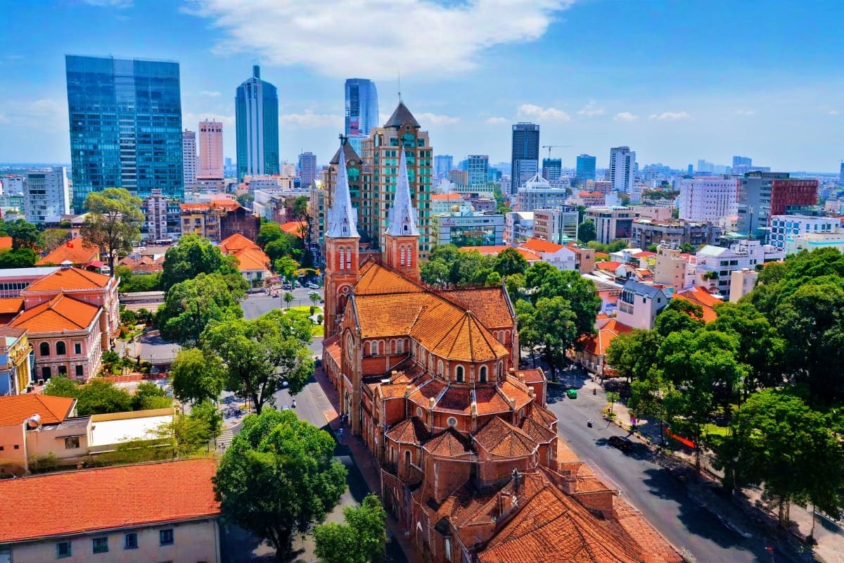 Ho Chi Minh Full day Sharing Tour Aerial view of Ho Chi Minh City skyline with Saigon Notre-Dame Cathedral and orange-roofed colonial buildings surrounded by m