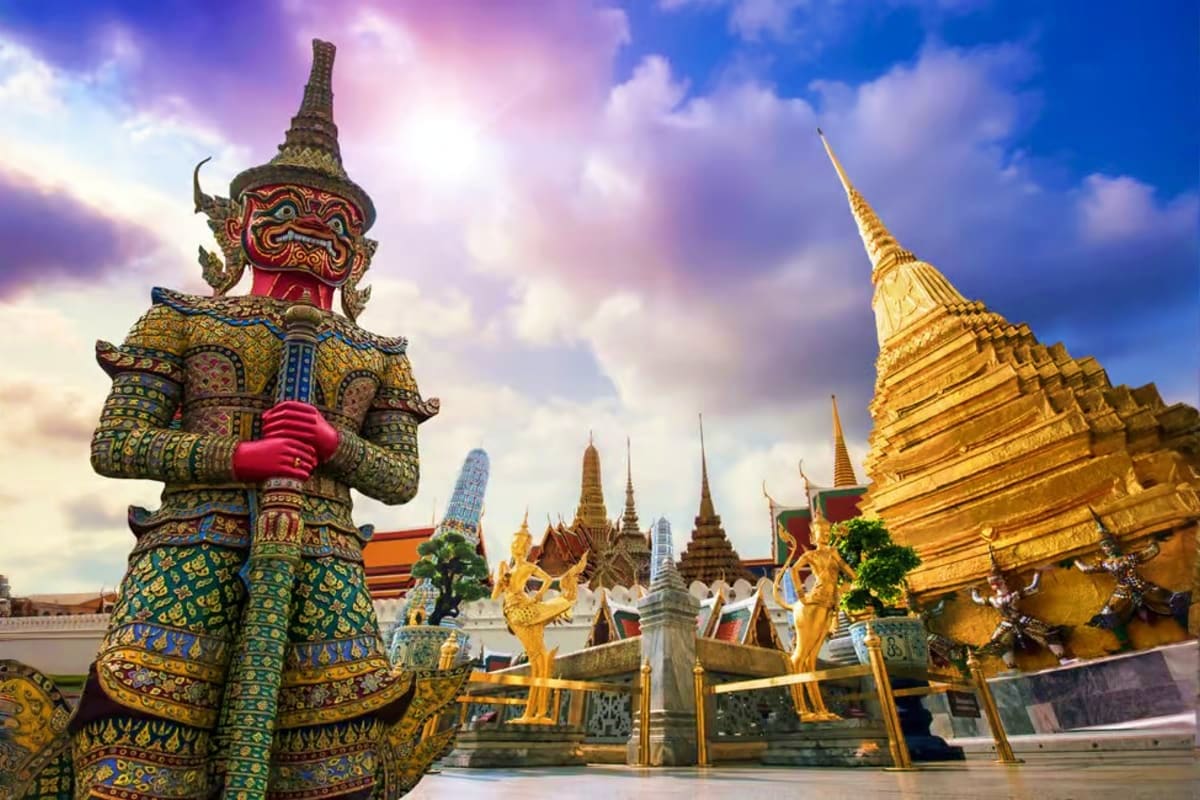 Bangkok City Tour Ornate golden demon guardian statue and spires of Grand Palace temple complex in Bangkok, Thailand