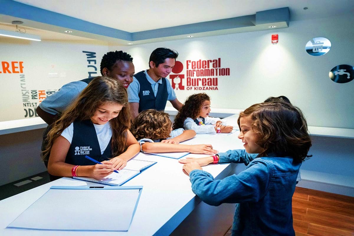 KidZania Abu Dhabi Children and adults engaged in interactive learning activity at KidZania Abu Dhabi's Federal Information Bureau educational e