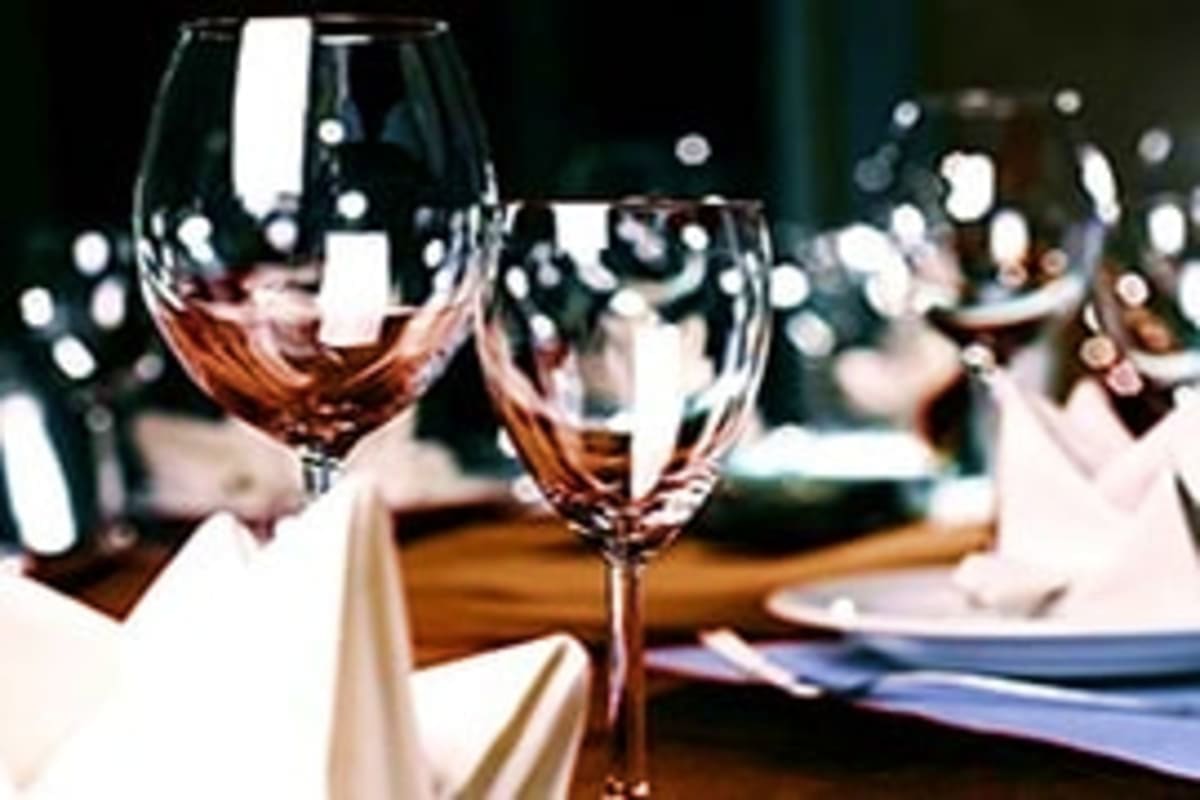 New Year Party In Dubai Marina Elegant wine glasses with rosé wine on a formal dining table set for celebration with bokeh lights in the background