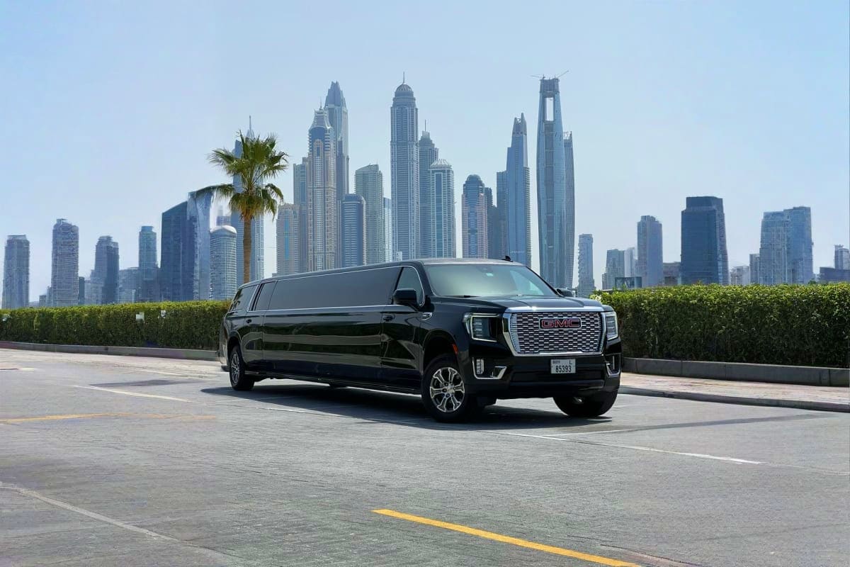 Black GMC Yukon limousine parked on rooftop with Dubai Marina skyscrapers in background
