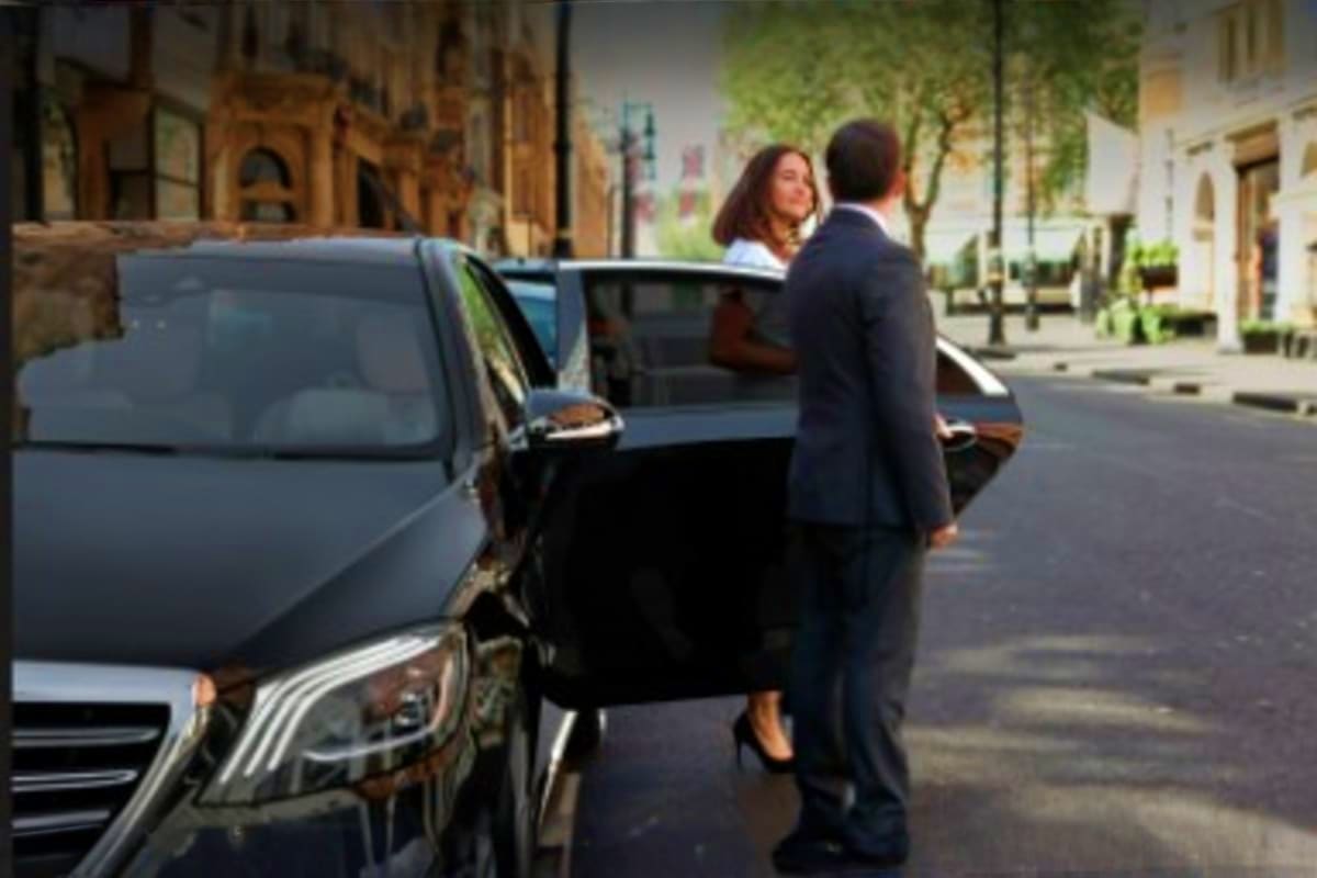 Ramadan Transfers Jeddah Hotel or Airport to Makkah Hotel Businessman assisting woman into black sedan on urban street for hotel or airport transfer service