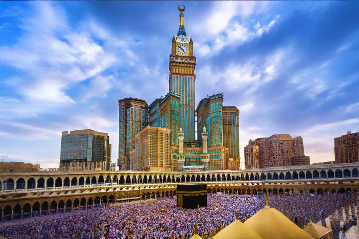 Ramadan Transfers Jeddah Hotel or Airport to Makkah Hotel Abraj Al-Bait clock tower overlooking the Kaaba with crowds of pilgrims in the Grand Mosque courtyard during Ramadan in Makka